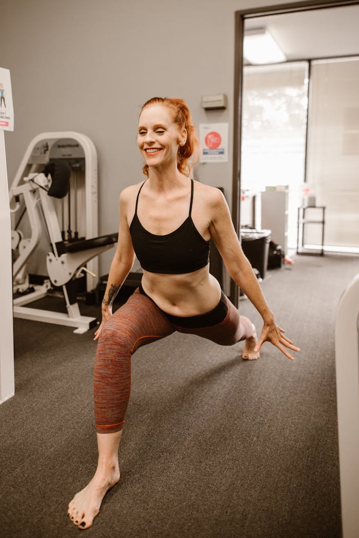 A woman performing yoga stretches in a fitness studio, enhancing wellness and flexibility.